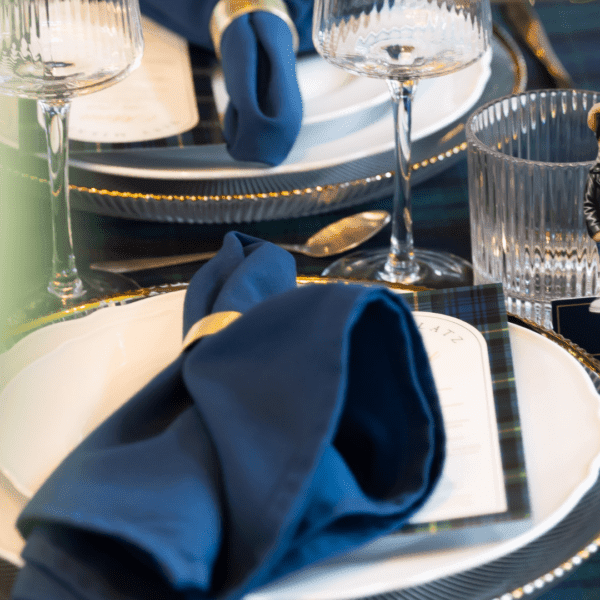 Navy blauwe servet tafelstyling bruiloft Navy blauwe servet gevouwen op bord met goud bestek bij stijlvolle bruiloft tafelstyling