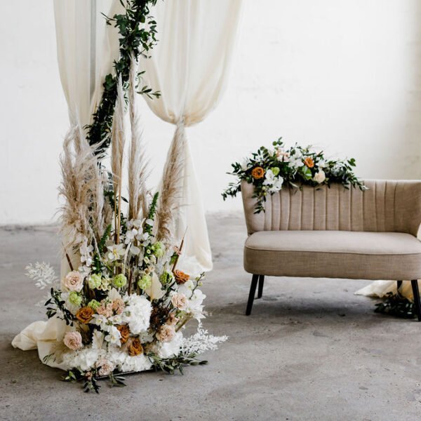 trouwbankje prieel met bloemen trouwbankje zandkleur backdrop rond zwart beige bankje bruiloft huren