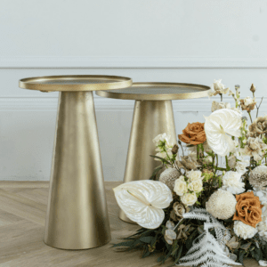 Gouden bijzettafels met bloemstuk gebruikt als decoratie bij bruiloft ceremonie
