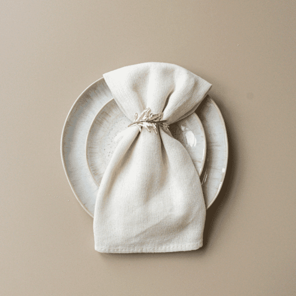 Gouden servetring voor bruiloftstafel Gouden servetring met takje op servet en bord – luxe tafelstyling voor bruiloftstafel