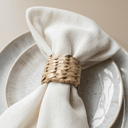 Rotan servetring met wit servet op bord – natuurlijke tafeldecoratie voor bruiloft