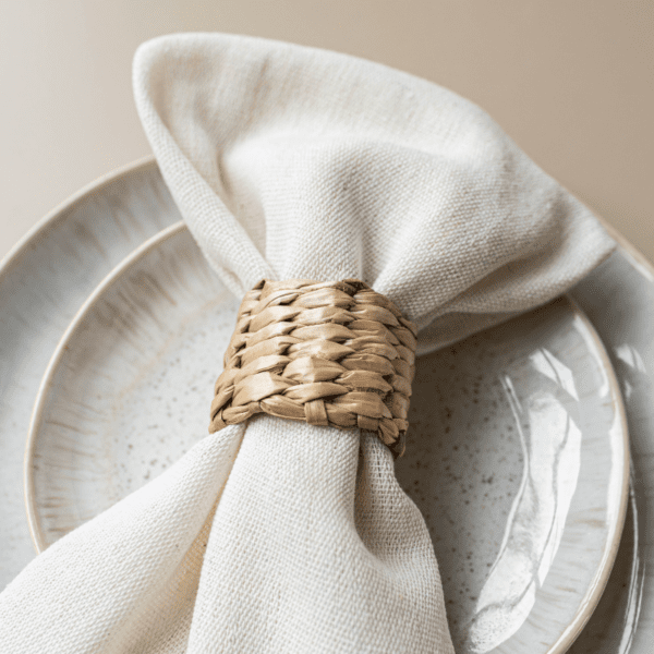 Rotan servetring met wit servet op bord – natuurlijke tafeldecoratie voor bruiloft