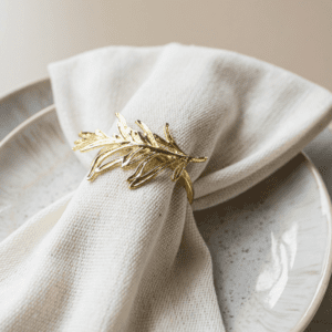 Gouden servetring met blad takje om linnen servet – stijlvolle tafeldecoratie voor bruiloft