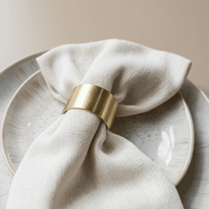 Gouden servetring met linnen servet op wit bord – luxe tafeldecoratie voor bruiloft