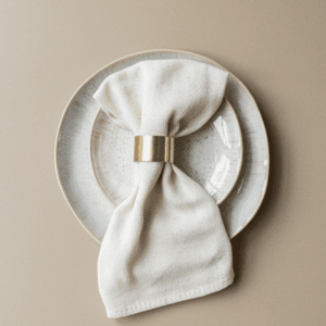 Gouden servetring met wit servet op bord – stijlvolle tafeldecoratie voor bruiloft of diner