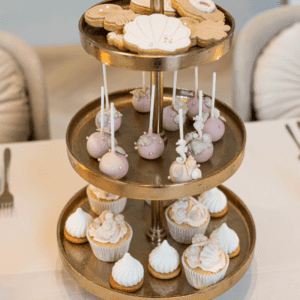 Gouden etagère met 3 lagen voor cupcakes en sweets Gouden etagère met 3 lagen gevuld met cupcakes en donuts op een stijlvolle sweet table