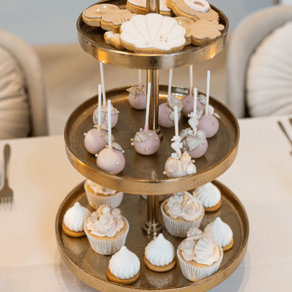 Gouden etagère met 3 lagen voor cupcakes en sweets Gouden etagère met 3 lagen gevuld met cupcakes en donuts op een stijlvolle sweet table