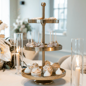 Gouden etagère met 3 lagen met cupcakes op een romantische dessert tafel voor bruiloft of feest