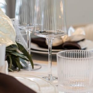 Detail van een helder wijnglas en waterglas met verticale ribbels Detail glaswerk met streep in het glas