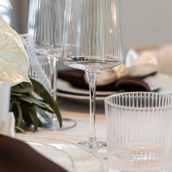 Detail van een helder wijnglas en waterglas met verticale ribbels Detail glaswerk met streep in het glas