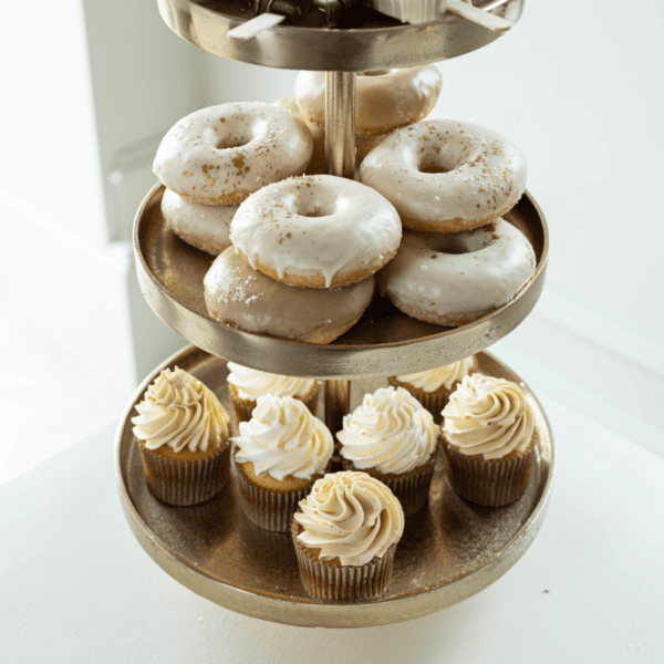 Cupcakes presenteren op gouden etagère met 3 lagen Gouden etagère met 3 lagen gevuld met cupcakes en donuts, ideaal voor sweet table op bruiloft of feest