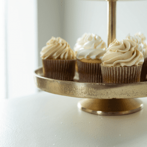 Gouden etagère met 3 lagen met cupcakes en donuts, stijlvolle presentatie voor bruiloft, babyshower of high tea