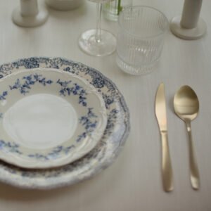 Elegante bruilofttafel met gestreepte wijnglazen Bruiloft tafel met geribbelde glazen, witte bloemen en hoge kaarsen