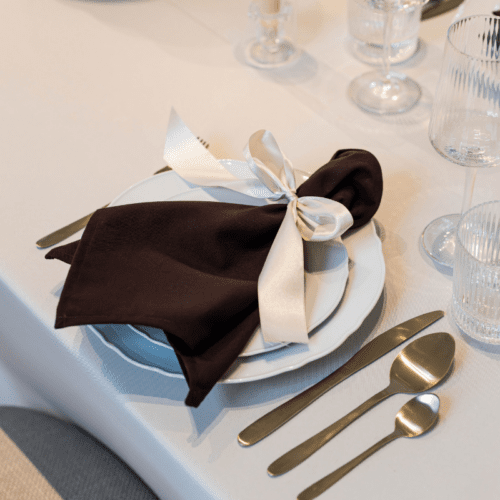 gedekte tafel met wit dinerbord met geschulpte rand en goud bestek voor bruiloft diner