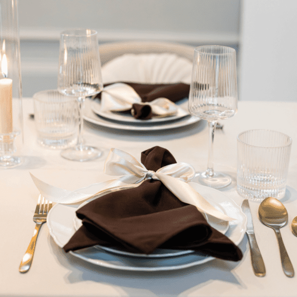 wit dinerbord met goud bestek tafelsetting wit dinerbord met geschulpte rand met donker servet en goud bestek voor luxe diner tafel
