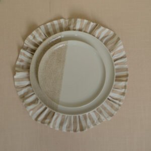 Wit-beige dinerbord op onderbord Tweekleurig wit-beige dinerbord op een gestreept onderbord