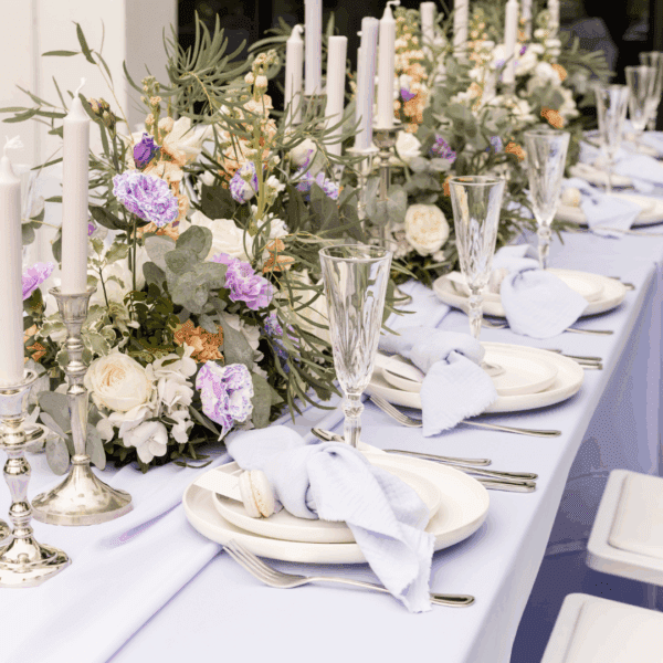 Zilver bestek op 21-diner Gedekte 21-diner tafel met zilverlook bestek en bloemen in pastelkleuren