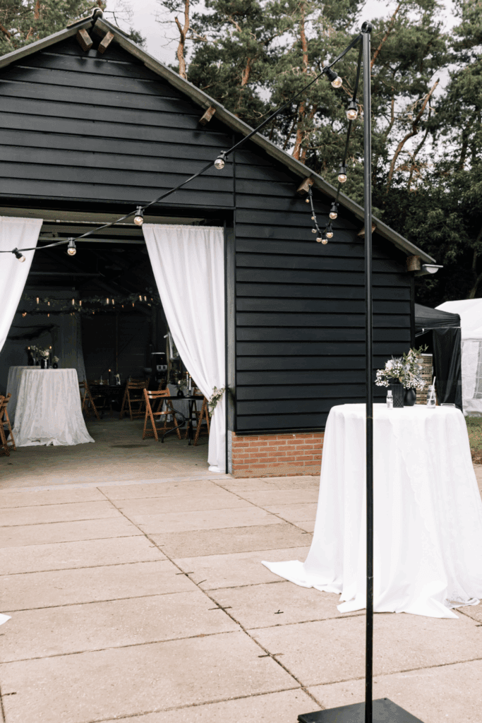 Buitenaanzicht van stijlvolle trouwlocatie met witte doeken bij entree – sfeer creëren met eenvoudige elementen