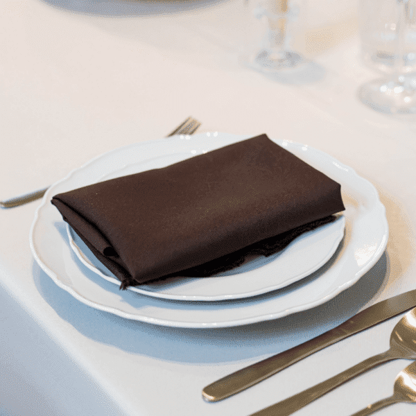bruine servet met servies bruine servet op stapel borden met goud bestek voor bruiloft of diner