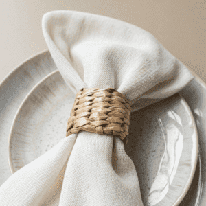 Beige bord met servet en rotan servetring Beige bord met servet en rotan servetring voor natuurlijke bruiloft tafel