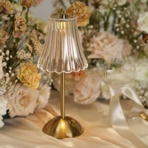 Gouden LED tafellamp zonder snoer met geplisseerde kap Gouden LED tafellamp zonder snoer met geplisseerde kap tussen zachte bloemen op een elegant gestylde bruiloftstafel