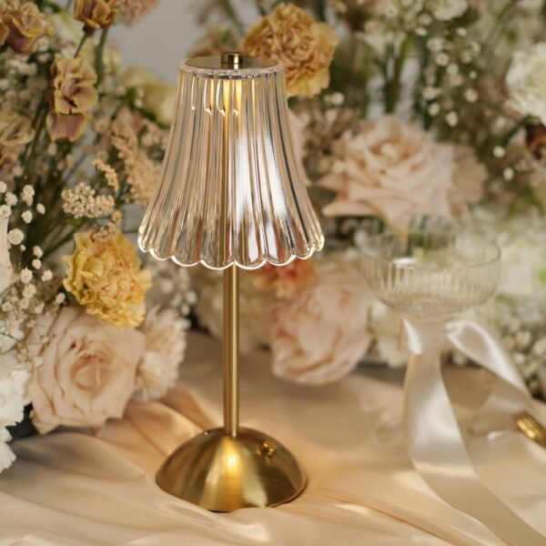 Gouden LED tafellamp zonder snoer met geplisseerde kap Gouden LED tafellamp zonder snoer met geplisseerde kap tussen zachte bloemen op een elegant gestylde bruiloftstafel