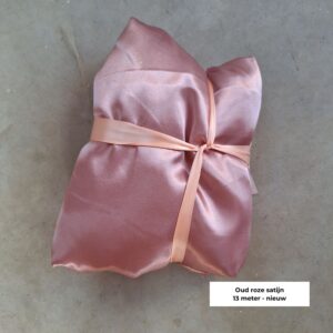 Oud roze outlet satijn stof van 13 meter voor tafellopers, tafelstyling en zachte decoratie bij een bruiloft.