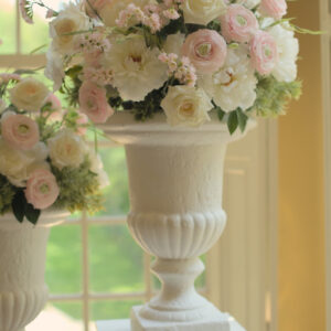 Grote witte vazen huren voor een ceremonie | Feline Styling Klassieke witte vaas gevuld met lichte bloemen en groene takken. Te huur bij Feline Styling voor bruiloft of 21-diner