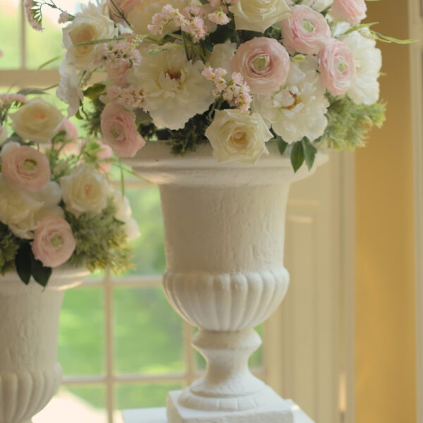 Grote witte vazen huren voor een ceremonie | Feline Styling Klassieke witte vaas gevuld met lichte bloemen en groene takken. Te huur bij Feline Styling voor bruiloft of 21-diner