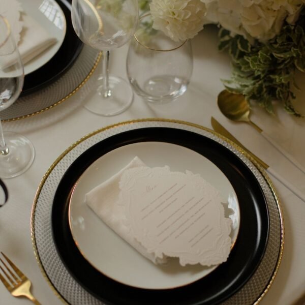 Waterglas bij luxe tafelsetting Waterglas met gouden rand bij wit servies en gouden onderbord