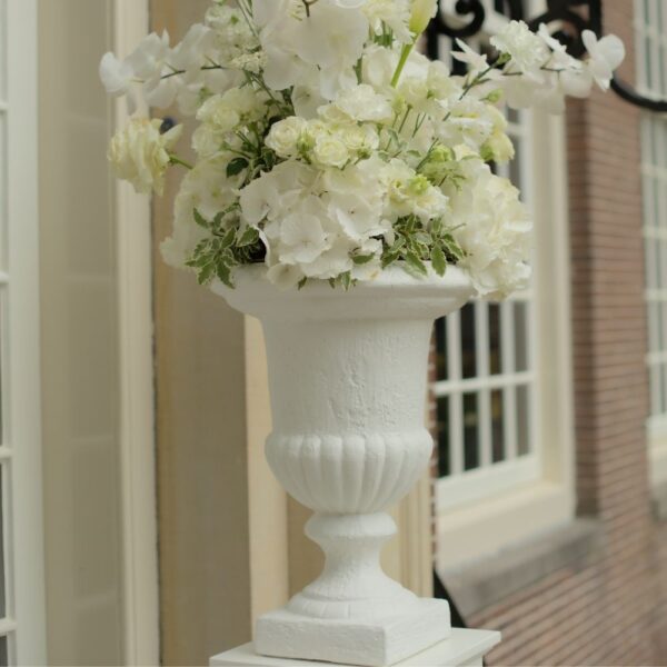 Klassieke witte vaas met bloemstuk voor ceremonie of entree