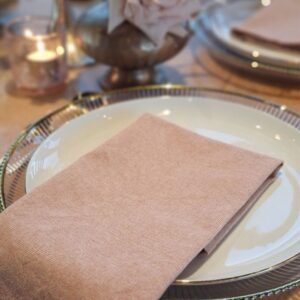 Terracotta roze servet op dinerbord Terracotta roze servet op wit dinerbord met gouden rand