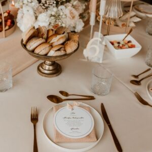 Terracotta roze servetten op lange dinertafel met gouden accenten
