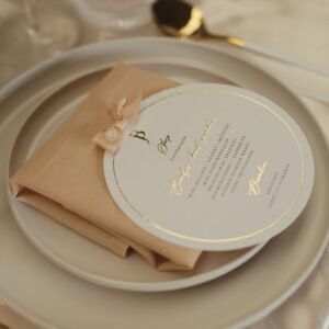 Perzik roze servet gevouwen op wit dinerbord
