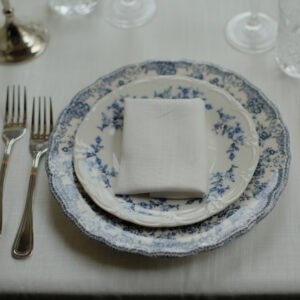 Franse tafelstyling met blauw-wit servies Klassiek porseleinen dinerbord met blauwe bloemen in Franse stijl, gecombineerd met linnen servetten.