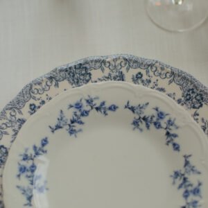 Servies huren voor een verlovingsfeest Klassiek dinerbord met blauwe bloemen op een sfeervol gedekte tafel voor een verlovingsfeest.