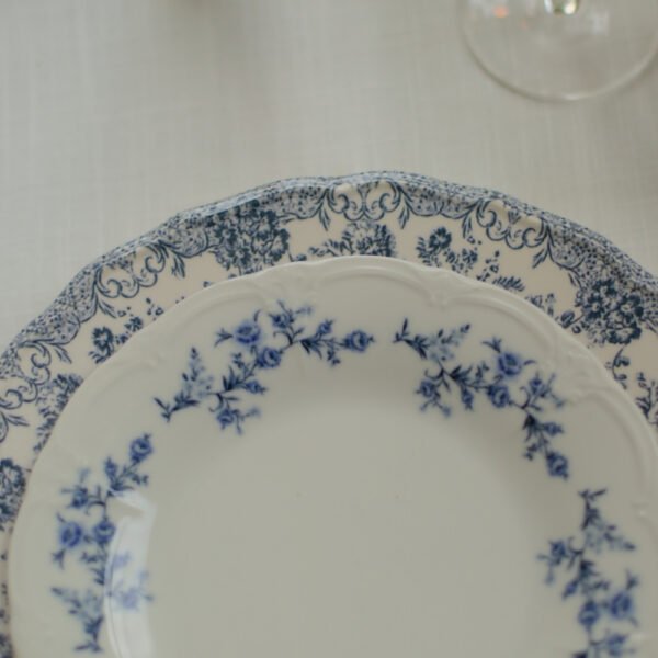 Servies huren voor een verlovingsfeest Klassiek dinerbord met blauwe bloemen op een sfeervol gedekte tafel voor een verlovingsfeest.