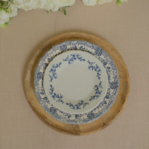Gedekte bruiloftstafel met klassiek dinerbord, blauwe bloemen en Franse uitstraling.