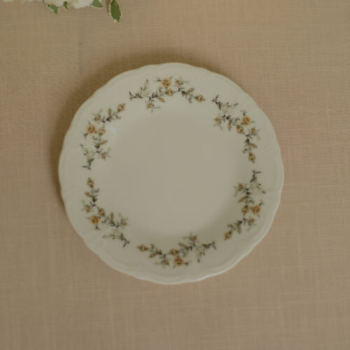 Wit porseleinen dinerbord met bloemenrand in crème, beige, bruin en donkergroen.
