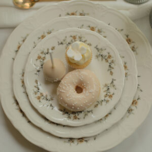 Romantisch ontbijtbord met bloemenrand, koffiemok en donuts voor een stijlvolle high tea.