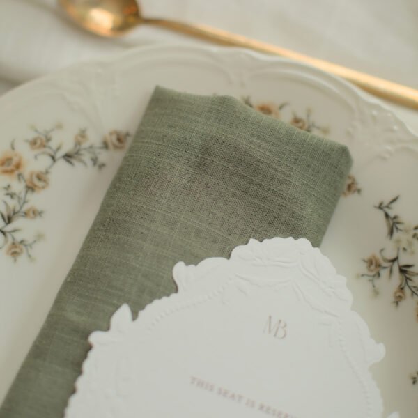 Romantisch servies met groen linnen servet Romantisch porseleinen servies met bloemenrand gecombineerd met een groen linnen servet.