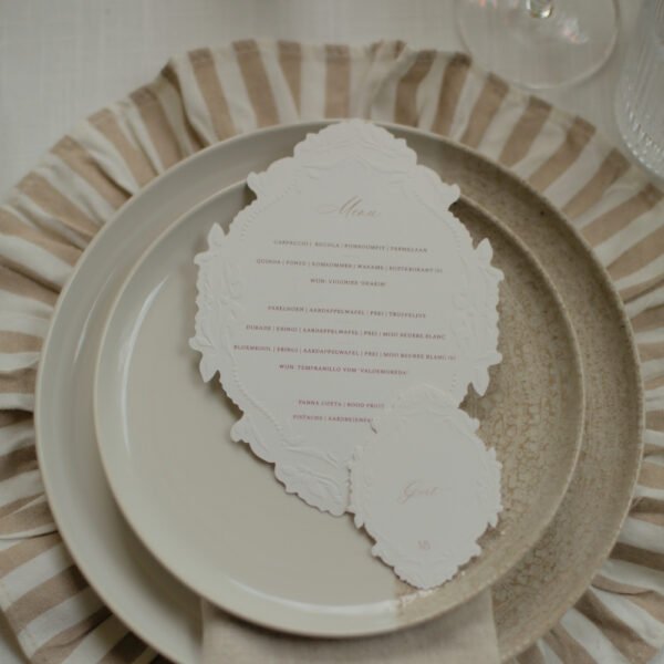 Wit-beige tafelsetting Tafelinspiratie voor een babyshower met stoffen onderbord en licht servies