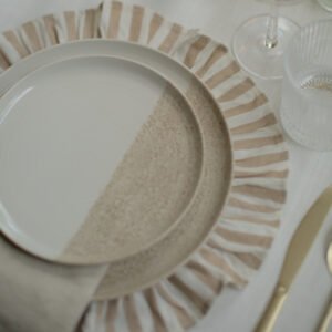 Gestreept onderbord met licht servies en beige servet